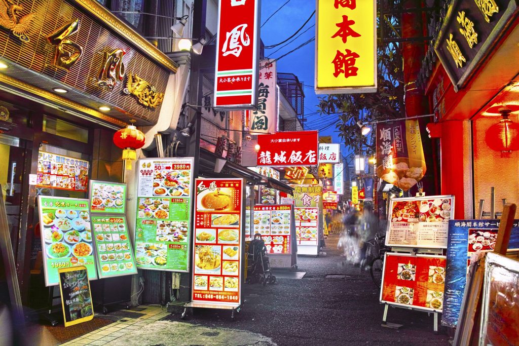 To the left: a woman handing out piping hot nikuman (meat buns) the size of a human head. To the right: customers eagerly walk into a gigantic panda’s mouth. No, you haven’t accidentally taken the red pill and ended up down a rabbit hole. You just happen to have stumbled upon the biggest Chinatown in Asia! It’s hard to miss Yokohama’s Chinatown. Although when you’re walking from Motomachi-Chukagai, everything seems quite ordinary. Normal grey buildings and gleaming white konbinis line the streets then suddenly color. Chinatown is a vivid concoction of red, blue and gold. “The air smells good enough to eat and the bubbly atmosphere is further animated by the cries of the street vendors.” Of course, if you’ve followed your nose (or more accurately, your stomach) then you have one thing on your mind: food. Chinatown has an abundance of reasonably priced restaurants and street food. All-you-eat courses can be found from 1,500 - 4000 yen, usually with a 90 minute limit. That’s 90 minutes to stuff yourself with the some of the best Chinese food in the world. The street food is highly recommended, so if you’re not too pregnant from your main course, check out the shumai (pork dumplings), shouronbou (the Japanese term for xiaolongbao, steamed buns with soup inside) and fried sesame balls. There’s more to this wonderful place than just its cuisine. If you’re interested in traditional Chinese architecture then the town’s five large gates and two temples, Kanteibyo and Masobyo, are well worth visiting. Shops selling traditional clothing like the qipao, charms, lanterns, incense, medicine, spices and seasonings, jewelry and (most importantly) panda memorabilia are also easily found down one of the winding alleyways characteristic of the area. Festivals such as the Lunar New Year (January/February), Lantern Festival (the month after New Year) and Mid-Autumn Festival (September) are truly a sight to behold. Huge crowds of revelers are treated to lion dances, firecrackers, martial arts and acrobatic performances as well as traditional Chinese music.